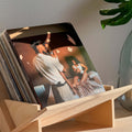 Stylish wood book and vinyl record holder displaying a music album in a modern home setting.