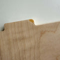 Close-up of wood panel with a small blemish showing chip and grain details, highlighting unique furniture imperfections.