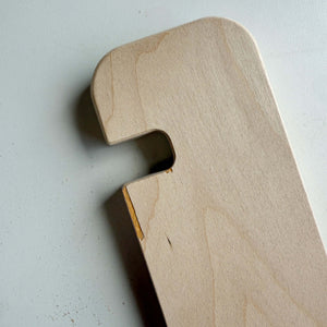 Close-up of a unique piece of blemished wood furniture with a cutout and small imperfections.