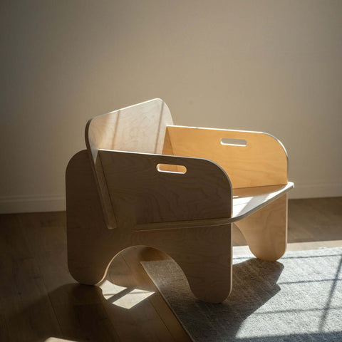 Modern plywood lounge chair with a sculptural silhouette, perfect for relaxing in cozy spaces.