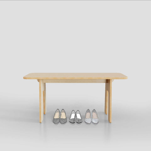 Wooden table with three pairs of stylish flats in silver and black arranged neatly in front.