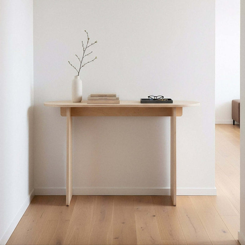 Oval Modern Console Table in a hallway with a vase and books