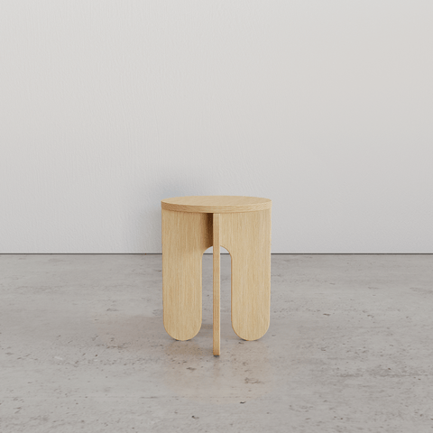 Minimalist wooden stool with round top and unique leg design, perfect for modern interiors.