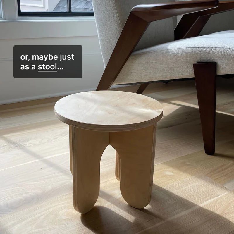 Minimalist wooden stool beside a chair, showcasing its simple design and versatility as furniture.