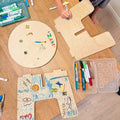 Toddler Stool components with colorful drawings and markers on a wooden table.