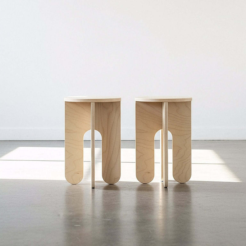 Two round side tables styled together in a light wood finish
