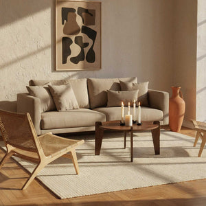 Round Coffee Table styled in a cozy living room with beige sofa, candles, and artistic decor.