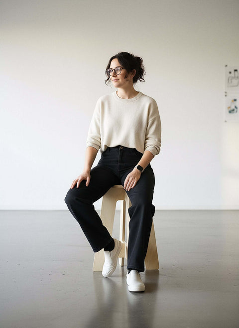 Woman sitting on A-Stool made of birch plywood, showcasing its clean lines and solid build in a modern space.